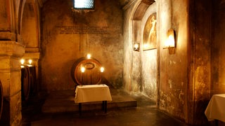 Ein altes Weinfass im Bremer Ratskeller, davor ein kleiner Tisch mit Kerzen.