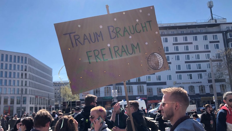 Auf dem Bremer Bahnhofsvorplatz demonstrieren Menschen für lockere Regeln für Open-Air-Partys.