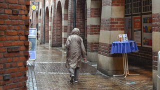 Eine Frau mit Regenmantel in Bremen.