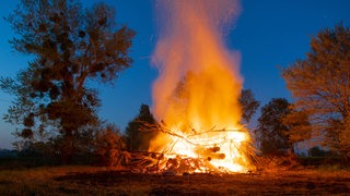 Osterfeuer lodert in der Abenddämmerung (Symbolbild)