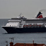 Ein weiß-blaues Kreuzfahrtschiff fährt über das Meer.