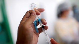 Eine Corona-Impfspritze wird aufgezogen (Symbolbild)