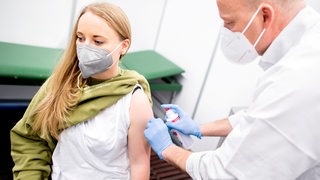 Eine junge Erzieherin wird in Bremen gegen Corona geimpft.