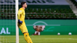 Werder-Torwart Jiri Pavlenka lehnt frustriert am Pfosten und starrt ins Leere.