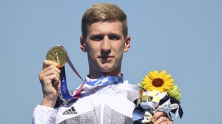 Schwimmer Florian Wellbrock hält bei der Siegerehrung seine Goldmedaille für den Sieg im zehn Kilometer-Rennen im Freiwasser hoch.