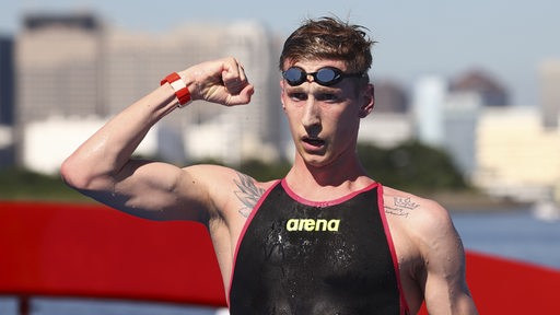 Schwimmer Florian Wellbrock zeigt nach seinem Gold-Rennen im Freiwasser selbstbewusst seinen rechten Bizeps.