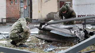 Ukrainische Polizeioffiziere inspizieren die Überreste einer russischen Rakete in Kiew