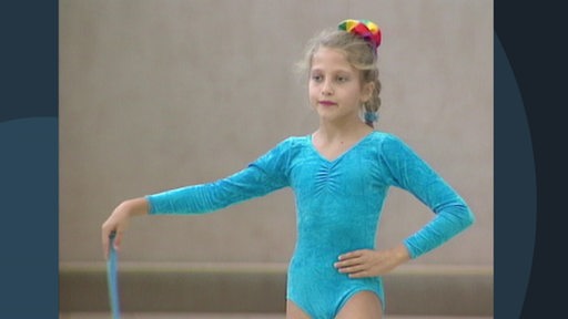 Ein junges Mädchen trainiert Rhytmische Sportgymnastik in der Gymnastikhalle vor 30 Jahren.
