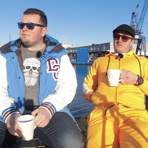 Das Duo "Ribtide" sitzen mit Kaffeetassen auf Klappstühlen vor Bremerhavener Kulisse