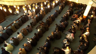 Männer beten in einer Moschee.