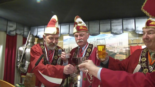 Die Ritter der Schlaraffia Brema stoßen gemeinsam in ihrem Vereinsraum mit alkoholischen Getränken an.