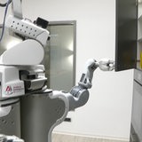 Ein Roboter öffnet einen Küchenschrank.