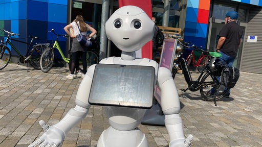 Ein Roboter steht vor einem Gebäude.