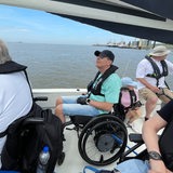 Rollstuhlfahrer sitzen auf einem Segelboot.