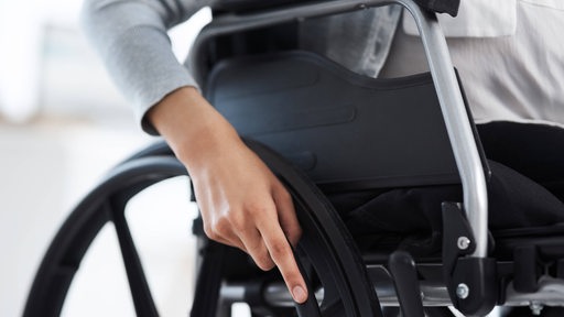 Eine Frau im Rollstuhl, die man nur zum Teil sieht (Symbolbild)