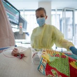 Eine Intensivpflegerin versorgt einen am Respiratorischen Synzytial-Virus erkrankten Patienten, der beatmet wird.