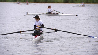 Eine nachwuchs-Rudererin mit ihrem Ruderboot auf dem Werdersee.