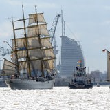 Drei Schiffe fahren auf der Weser. Im Hintergrund ist das Sail-City-Hotel in Bremerhaven zu sehen.