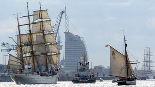 Drei Schiffe fahren auf der Weser. Im Hintergrund ist das Sail-City-Hotel in Bremerhaven zu sehen.