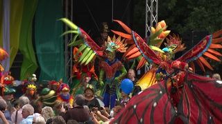 Tänzerinnen auf Stelzen in bunten Kostümen beim Samba Karneval.