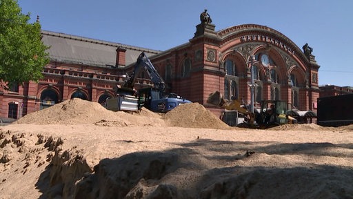 Der Sand des temporären Volleyballplatzes am Hauptbahnhof wird abgebaggert.