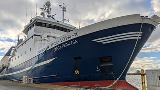 Ein Schiff liegt an einem Pier.