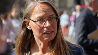 Eine Frau mit glatten Haaren und Brille, Bremens Bildungssenatorin Sascha Aulepp, gibt ein Interview.