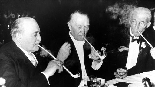 Bremens Senatspräsident Wilhelm Kaisen, Bundeskanzler Konrad Adenauer und Hans Henry Lamotte, einer der vier Vorsteher des "Haus der Seefahrt" beim traditionellen Tonpfeifen-Rauchen während der Schaffermahlzeit 1954