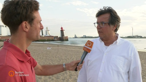 Janosz Kereszti interviewt den Chef einer Firma vor dem Molenturm.