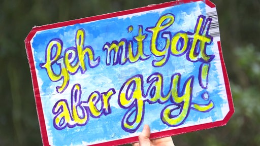 Ein Schild beim Protest: "Geh mit Gott aber gay!".