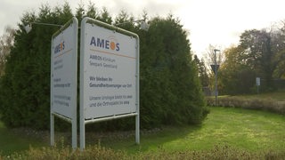 Vor grünen Büschen steht ein Schild des AMEOS Klinikum in Geestland.