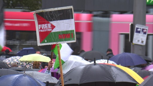 Eine Person hält ein Free Palestina Schild auf der Demonstration am Bremer Hauptbahnhof hoch.