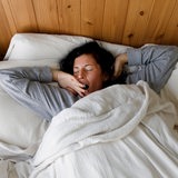 Eine Frau liegt gähnend in ihrem Bett