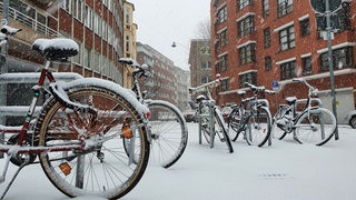 Abgestellte Fahrräder im Schneee in Bremen.