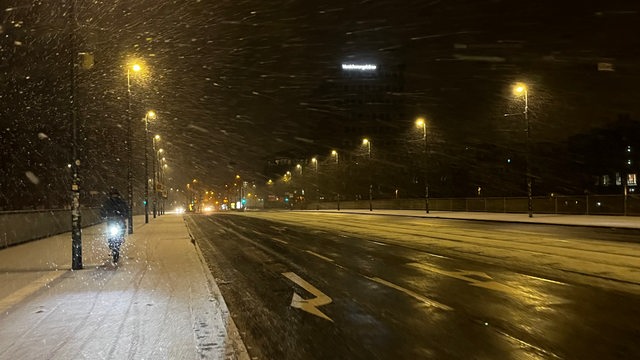 Auf der Wilhelm-Kaisen-Brücke in Bremen ist ein Radfahrer im Schnee unterwegs.