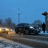 Autos fahren auf einer Straße, auf der Schnee liegt.