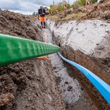 Glasfaserkabel werden in die Erde verlegt.