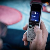 Eine Person hält ein klingelndes Telefon in der Hand.
