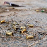 Abgefeuerte Patronenhülsen einer Schreckschusspistole liegen auf dem Boden.