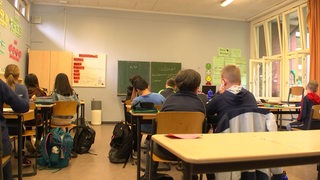 Schüler sitzen in einem Klassenraum und haben Unterricht.
