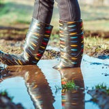 Bunte Gummistiefel in einer Pfütze.