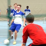 Mehrere junge Männer spielen Fußball.