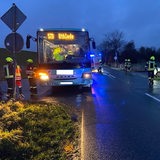 Einsatzkräfte stehen neben einem Bus auf einer Straße.