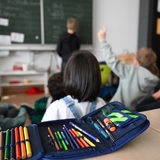 Schüler einer Grundschule arbeiten in einem Klassenzimmer an Mathematikaufgaben.