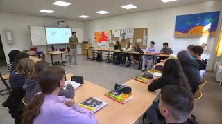 Ein Lehrer hält eine Unterrichtsstunde für Schüler