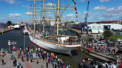 Das Schulschiff Deutschland in Bremerhaven mit vielen Menschen davor.