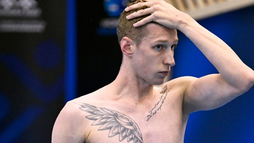 Schwimm-Star Florian Wellbrock fasst sich nach seinem Vorlauf-Aus im Becken bei der WM konsterniert an den Kopf.
