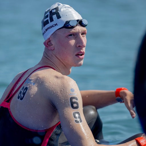 Schwimm-Olympiasieger Florian Wellbrock hockt nach dem enttäuschenden Abschneiden im Freiwasser-Rennen bei der WM in Katar am Steg.