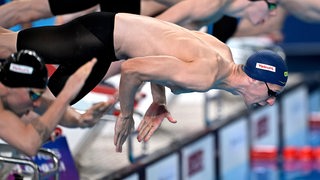 Schwimm-Star Florian Wellbrock beim Absprung ins Becken zum 1.500-Meter-Vorlauf bei der WM in Doha.