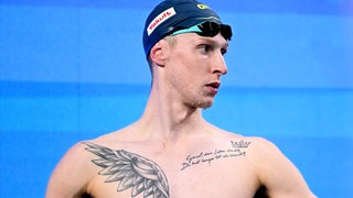 Schwimm-Olympiasieger Florian Wellbrock schaut nachdenklich vor dem Start bei einem WM-Lauf im Beckenwettbewerb zur Seite.